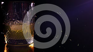 Close-up. Top  Side of Pouring Glass of Whiskey. Pouring of scotch whiskey or cognac into glasses with ice cubes on dark