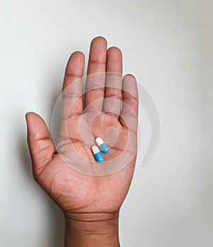Close up top view on an African male hand holding two pills