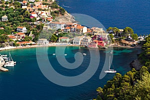 Close up top view at Asos village, Assos peninsula and fantastic turquoise and blue Ionian Sea water. Aerial view