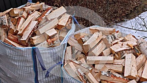 Close-up top view of birch firewood in transport bags on a winter-spring day.