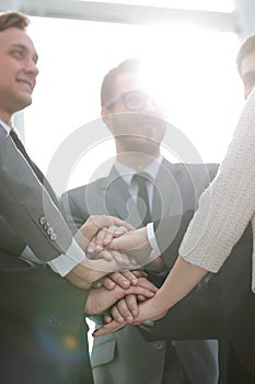 Close up top view of business people putting their hands togethe