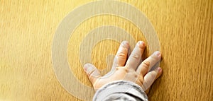 Close up top view of child`s hand  on wooden background