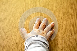 Close up top view of child`s hand  on wooden background