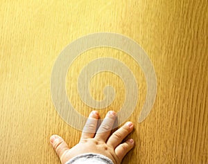 Close up top view of child`s hand  on wooden background