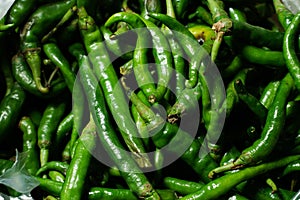 Close up top view of freshly harvested green chillies  displayed in market for sale.