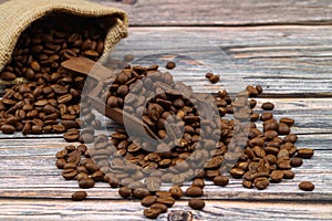 Close-up and top view of hot black coffee in blue coffee cup and roasted Thai coffee beans on wooden background