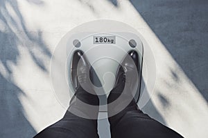 Close up and top view of man feet on scales asking for help. Lose weight concept