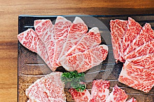 Close-up top view of Premium Rare Slices many parts of Wagyu A5 beef with high-marbled texture on stone plate. photo