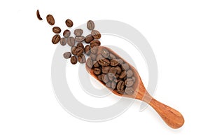 Close up and top view roasted coffee beans on wooden scoop isolated and white background