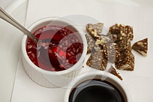 Close up top view shot of two white cups with soy sauce and red vinegar mignonette marinade with shallots inside, on a white plate