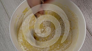 Close-up, top view, stirring ingredients for the dough in a plate with a spoon