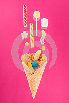 Close-up top view of tasty crispy waffle cone and mix of delicious sweets