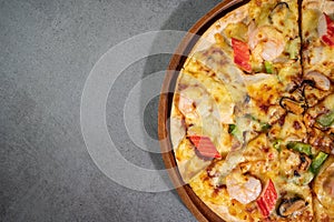 Close up top view of tasty hot baked seafood crispy pizza - mussels, shrimps and kani with chili pepper and melted mozzarella