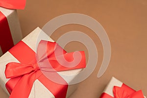 Close-up brown paper gift box red bow ribbon brown background. concept for happy love gift