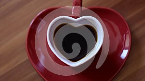 Close up top view of two small espresso cups with raising steam. Concept. Woman hand putting cup on the plate, stylish