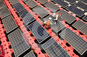 Close up and top view of two technician workers check and maintenance solar cell panel over the water reservoir as solar farm