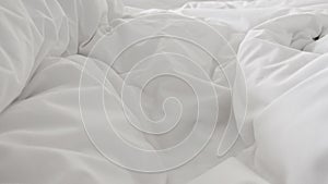 Close up top view of white pillow on bed and with wrinkle messy blanket in bedroom