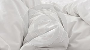 Close up top view of white pillow on bed and with wrinkle messy blanket in bedroom