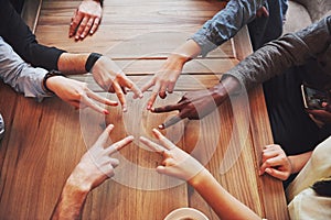 Close up top view of young people putting their hands together. Friends Doing a Star Shape with fingers showing unity