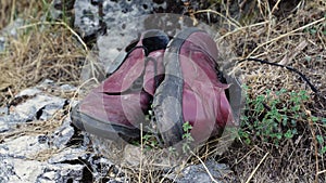 close-up of torn leather shoes thrown into the street. Human garbage pollutes nature on the planet
