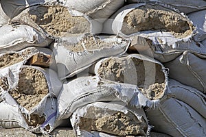 Close-up of torn sandbags furnished around historical monuments and roadblocks during martial law in Ukraine. War in Ukraine photo
