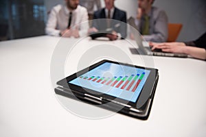 close up of touchpad with analytics documents at business meeting