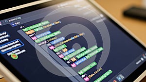 Close-up of touchscreen showing coding lesson with animated syntax highlights, tech education