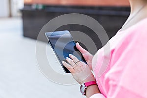 Close up of touchscreen tablet are used by woman on the summer street