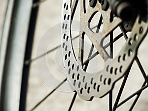 Close up touring bicycle disc brake at front wheel in selective focus.