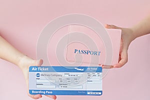 Close up tourist female horizontal hold in hand tickets for plane with orange passport, boarding pass, isolated on yellow