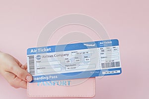 Close up tourist female horizontal hold in hand tickets for plane with orange passport, boarding pass, isolated on yellow