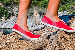 Close up of a tourist girl feet wearing red shoes hiking on cefalonia island, mediterranean, greece