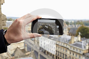 Close Up Of Tourist Taking Photo Of Oxford Skyline Using Phone