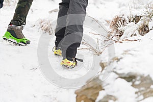 Close-up of tourists& x27; legs and their winter boots with crampons.