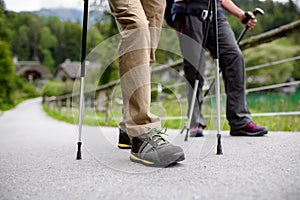 Close up of tourists walking with trekking poles.