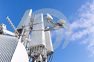 Close-up of a tower with a 5G and 4G cellular network antenna against a blue sky