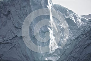 Close up of towering wall of textured massive iceberg