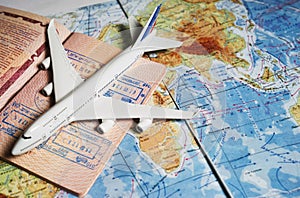 Close up the toy airplane and passport on the world map background. Travel and business concept