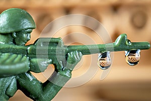 Close up toy soldier with tank reflection in drops