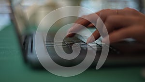 Close-up tracking shot of unrecognizable female hands of business woman using typing on laptop keyboard sitting at home