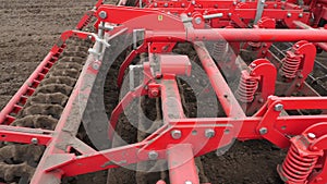Close-up, tractor cultivator cultivates, digs the soil. tractor plows the field. automated tiller for digging soil in