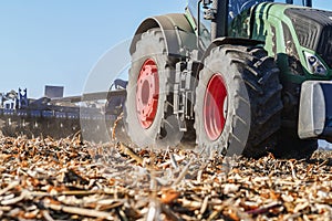 Close up of tractor with equipment for disking soil after corn harvesting.