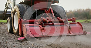 Close-up of a tractor with a plow plowing a field on an autumn day