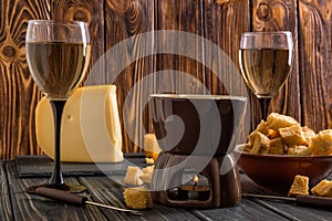 Close up. Traditional alpine cheese fondue. Burning candle heats fondue pot. Winter seasonal meal. Copy space