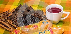 Close up of traditional Ecuadorian dish, colada morada and guaguas de pan, with assorted species to prepare, over a