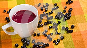 Close up of traditional Ecuadorian dish, colada morada with some mortinos, over a colorful fabric