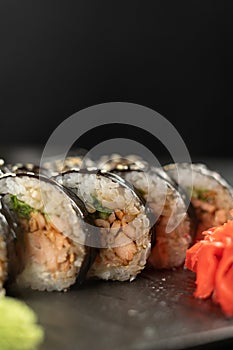Close-up of traditional fresh japanese sushi futomaki on black background