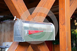 Close-up of traditional mailbox, metal box with a red lever for the postman on a wooden fence, communication and message concept