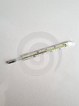 Close Up Traditional medical mercury-in-glass thermometer for measuring high body temperature in hand