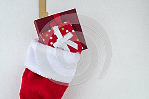 Close up of traditional red and white plush Christmas stocking stuffed with two wrapped presents